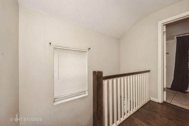 corridor featuring lofted ceiling and wood finished floors