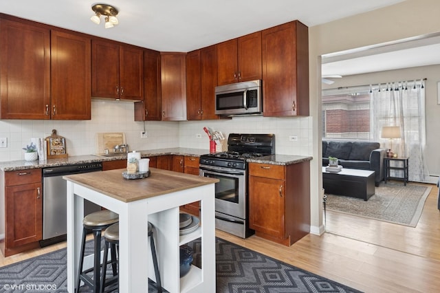 2652 W Rascher Ave Unit 304, Chicago, IL 60625 - kitchen featuring stainless steel appliances, light wood finished floors, tasteful backsplash, light stone counters, and a ceiling fan
