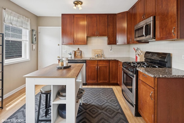2652 W Rascher Ave Unit 304, Chicago, IL 60625 - kitchen featuring stainless steel appliances, light wood finished floors, dark stone countertops, and tasteful backsplash