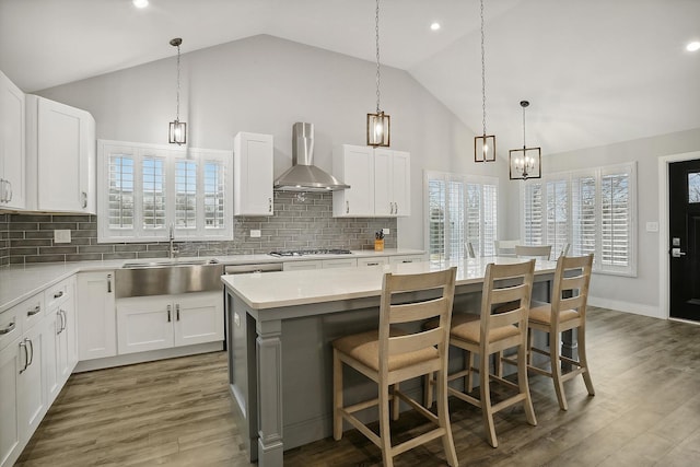 8081 Tennessee Ave, Willowbrook, IL 60527 - kitchen featuring wall chimney exhaust hood, light countertops, high vaulted ceiling, backsplash, and white cabinetry