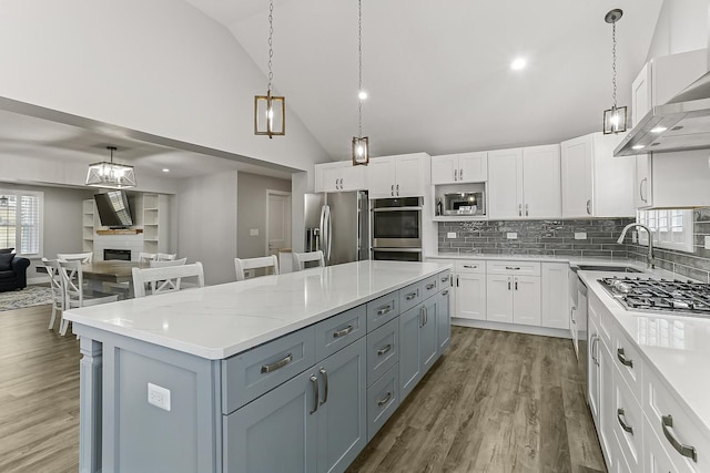 8081 Tennessee Ave, Willowbrook, IL 60527 - kitchen featuring appliances with stainless steel finishes, extractor fan, white cabinetry, high vaulted ceiling, and a center island