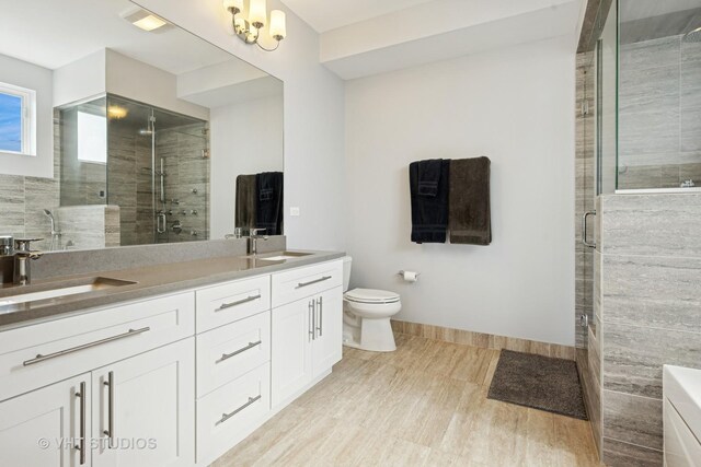 2442 N Clybourn Ave Unit 5S, Chicago, IL 60614 - bathroom featuring double vanity, a shower stall, and wood finished floors