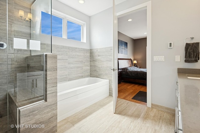 2442 N Clybourn Ave Unit 5S, Chicago, IL 60614 - ensuite bathroom featuring a garden tub, tiled shower, wood finished floors, recessed lighting, and vanity
