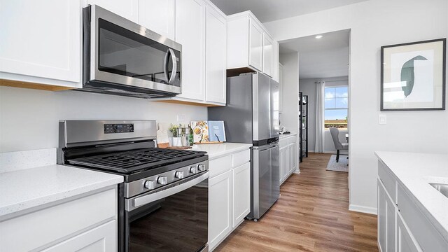 1818 Legacy Pointe Blvd, Plainfield, IL 60586 - kitchen featuring appliances with stainless steel finishes, light wood-type flooring, white cabinetry, recessed lighting, and light stone counters