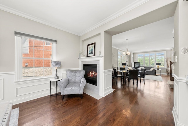 17946 Fountain Cir, Orland Park, IL 60467 - living area with a glass covered fireplace, ornamental molding, a chandelier, dark wood-style floors, and a wainscoted wall
