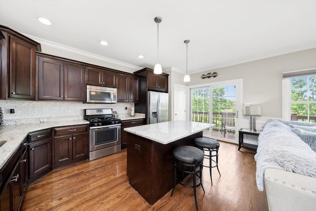 17946 Fountain Cir, Orland Park, IL 60467 - kitchen with stainless steel appliances, a breakfast bar area, dark brown cabinetry, open floor plan, and healthy amount of natural light