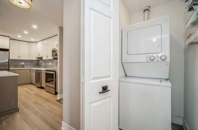 1250 Rudolph Rd Unit 4N, Northbrook, IL 60062 - washroom featuring stacked washer and clothes dryer, light wood-style floors, and recessed lighting