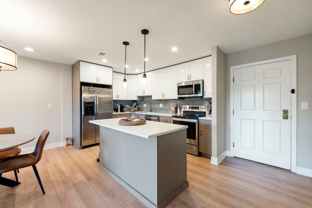 1250 Rudolph Rd Unit 4N, Northbrook, IL 60062 - kitchen featuring stainless steel appliances, light countertops, light wood-style flooring, a kitchen island, and white cabinets