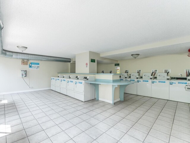 2754 N Hampden Ct Unit 1003, Chicago, IL 60614 - kitchen with a peninsula, washing machine and dryer, light countertops, a textured ceiling, and a kitchen breakfast bar