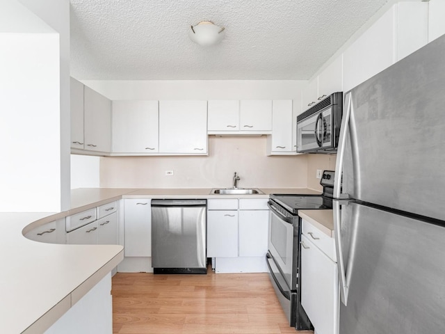 2754 N Hampden Ct Unit 1003, Chicago, IL 60614 - kitchen with appliances with stainless steel finishes, light wood finished floors, light countertops, white cabinetry, and a textured ceiling