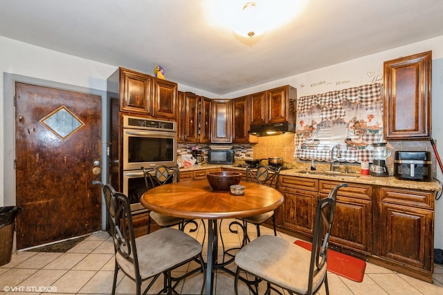 4322 W Walton St, Chicago, IL 60651 - kitchen with double oven, light tile patterned floors, under cabinet range hood, and tasteful backsplash