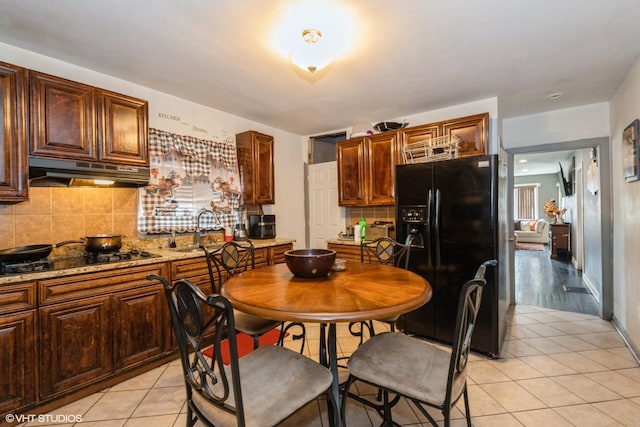 4322 W Walton St, Chicago, IL 60651 - kitchen featuring black appliances, under cabinet range hood, decorative backsplash, and light tile patterned floors