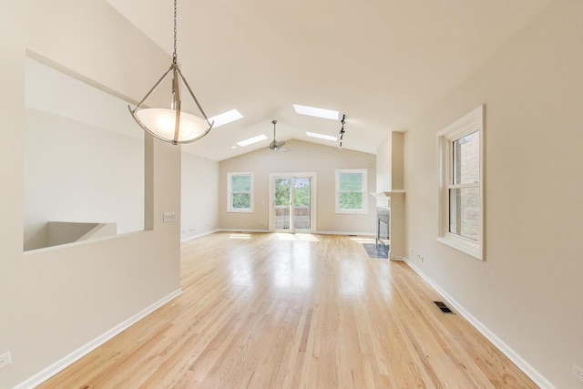 3319 N Seminary Ave Unit 3, Chicago, IL 60657 - unfurnished living room featuring lofted ceiling, wood finished floors, a skylight, and a fireplace with flush hearth