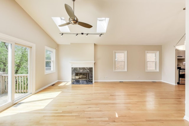 3319 N Seminary Ave Unit 3, Chicago, IL 60657 - unfurnished living room featuring a skylight, rail lighting, light wood finished floors, a premium fireplace, and vaulted ceiling