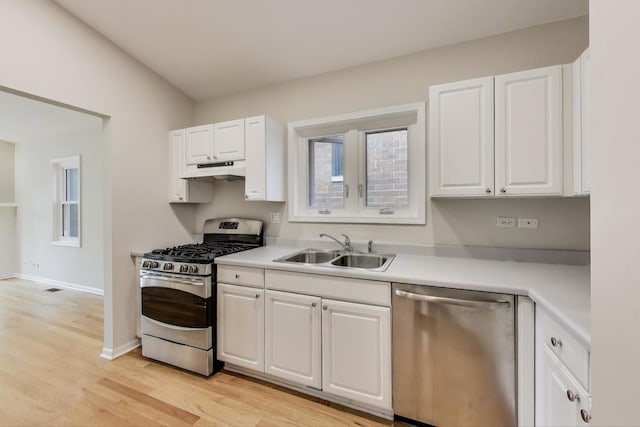 3319 N Seminary Ave Unit 3, Chicago, IL 60657 - kitchen featuring appliances with stainless steel finishes, under cabinet range hood, white cabinetry, light wood-type flooring, and light countertops