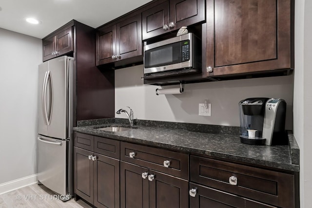 33 Citation Cir, Wheaton, IL 60189 - kitchen featuring appliances with stainless steel finishes, dark brown cabinetry, dark stone counters, light wood-type flooring, and recessed lighting