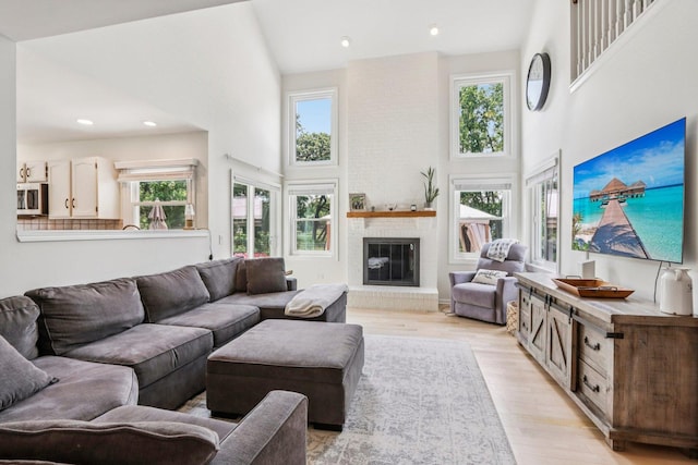7004 Bennington Dr, Gurnee, IL 60031 - living area featuring a towering ceiling, plenty of natural light, a brick fireplace, light wood-style floors, and recessed lighting