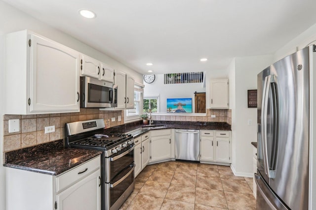 7004 Bennington Dr, Gurnee, IL 60031 - kitchen featuring appliances with stainless steel finishes, white cabinetry, decorative backsplash, dark stone counters, and recessed lighting