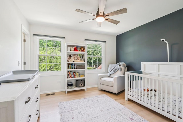 7004 Bennington Dr, Gurnee, IL 60031 - bedroom featuring light wood-type flooring, a nursery area, and ceiling fan