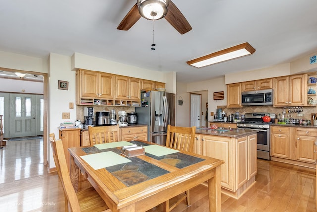 420 Fairway View Dr, Algonquin, IL 60102 - kitchen featuring stainless steel appliances, decorative backsplash, a kitchen island, a ceiling fan, and light wood-style flooring