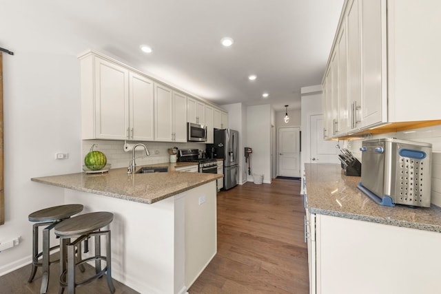 1580 Wind Energy Pass, Batavia, IL 60510 - kitchen with appliances with stainless steel finishes, backsplash, a peninsula, recessed lighting, and light stone counters