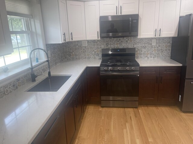 1530 S Greenwood Ave, Park Ridge, IL 60068 - kitchen with gas stove, light wood-type flooring, white cabinetry, and backsplash