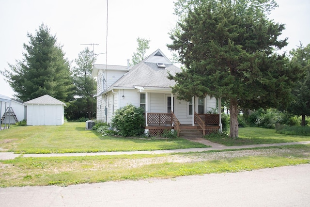 108 N Grove St, Harmon, IL 61042 - view of front facade with a porch, a front lawn, roof with shingles, and a shed