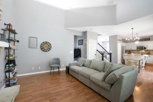 10628 Great Plaines Dr, Huntley, IL 60142 - living area with stairway, a high ceiling, light wood-style flooring, and a chandelier