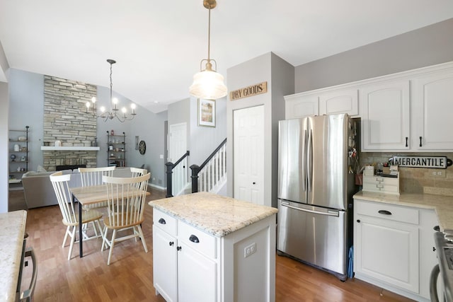 10628 Great Plaines Dr, Huntley, IL 60142 - kitchen featuring freestanding refrigerator, backsplash, white cabinets, wood finished floors, and lofted ceiling