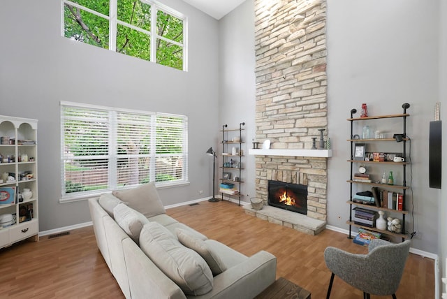 10628 Great Plaines Dr, Huntley, IL 60142 - living room featuring a towering ceiling, wood finished floors, and a stone fireplace
