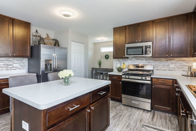 1307 Colaric Dr, Joliet, IL 60431 - kitchen featuring appliances with stainless steel finishes, decorative backsplash, light countertops, light wood-style floors, and dark brown cabinets