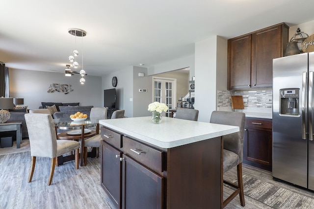 1307 Colaric Dr, Joliet, IL 60431 - kitchen featuring stainless steel fridge, open floor plan, a breakfast bar area, decorative backsplash, and a center island
