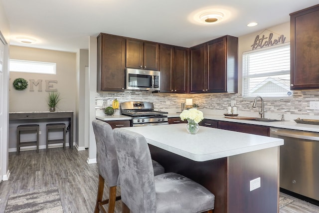 1307 Colaric Dr, Joliet, IL 60431 - kitchen featuring appliances with stainless steel finishes, a breakfast bar area, light countertops, and decorative backsplash