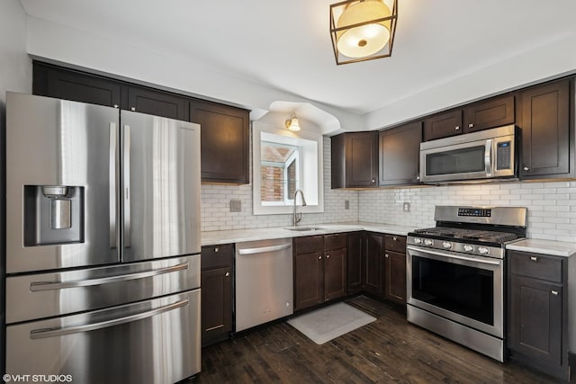 1628 Kenilworth Ave, Berwyn, IL 60402 - kitchen featuring appliances with stainless steel finishes, dark brown cabinets, dark wood-type flooring, and backsplash