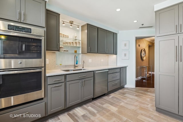 25 E Superior St Unit 2402, Chicago, IL 60611 - kitchen with stainless steel appliances, gray cabinetry, tasteful backsplash, light countertops, and light wood-style flooring