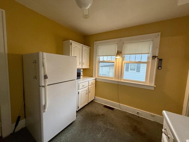 505 N Fair St, Champaign, IL 61821 - kitchen with freestanding refrigerator, white cabinetry, and light countertops