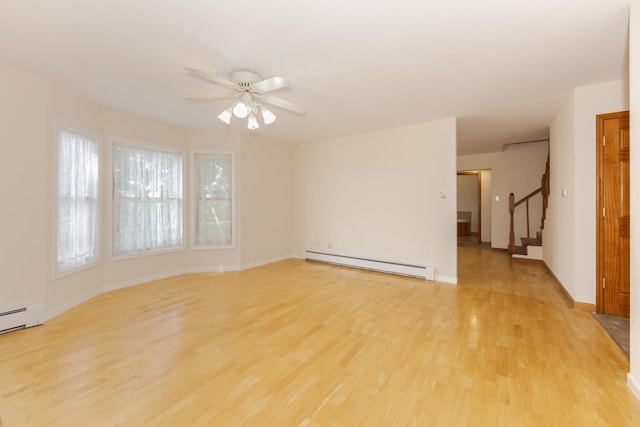 22998 E 2800 N Rd, Odell, IL 60460 - unfurnished living room featuring a baseboard heating unit, light wood finished floors, ceiling fan, and stairs