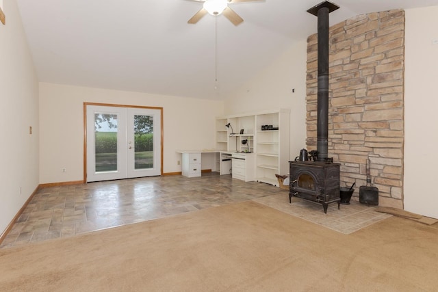 22998 E 2800 N Rd, Odell, IL 60460 - unfurnished living room featuring a wood stove, ceiling fan, french doors, high vaulted ceiling, and carpet floors
