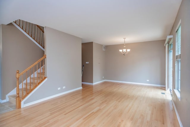 133 W Park Ave Unit A, Sugar Grove, IL 60554 - empty room with light wood finished floors, a chandelier, and stairs
