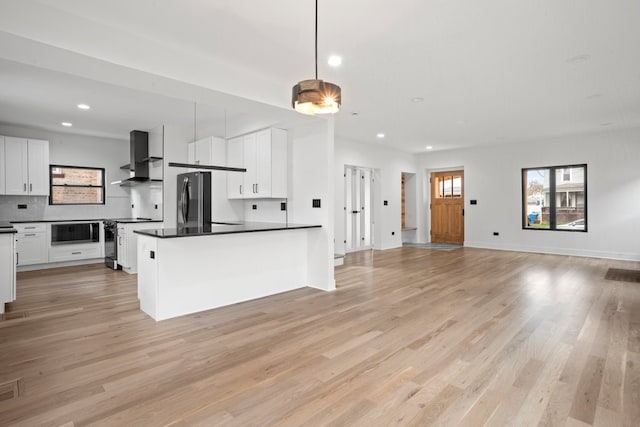 2305 W 111th Pl, Chicago, IL 60643 - kitchen with stove, freestanding refrigerator, dark countertops, open floor plan, and wall chimney range hood