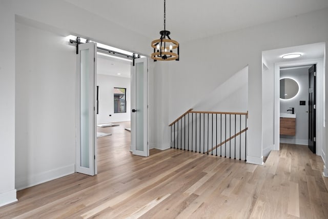 2305 W 111th Pl, Chicago, IL 60643 - hall featuring an upstairs landing, a barn door, light wood-style flooring, and a chandelier