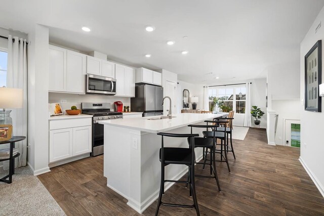 6335 Ulster Dr, Tinley Park, IL 60477 - kitchen featuring stainless steel appliances, an island with sink, dark wood-style flooring, recessed lighting, and a breakfast bar area