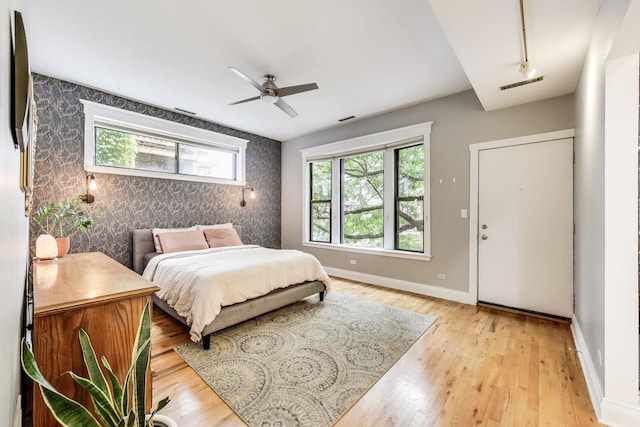 4611 N Magnolia Ave Unit 2, Chicago, IL 60640 - bedroom with wallpapered walls, an accent wall, light wood-style floors, and ceiling fan