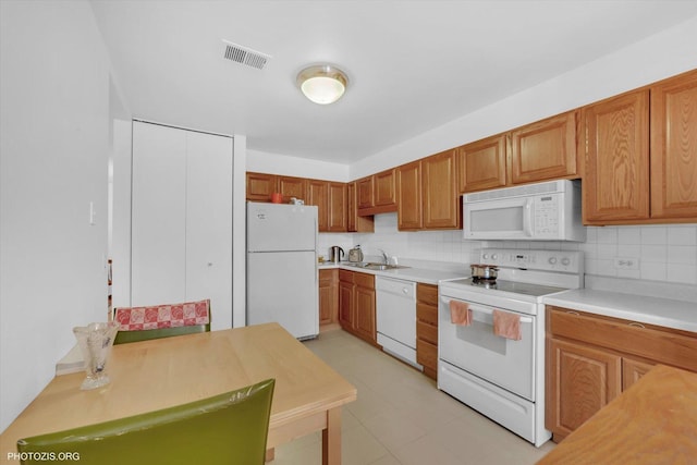4838 Howard St Unit 301, Skokie, IL 60077 - kitchen featuring white appliances, tasteful backsplash, light countertops, and brown cabinetry