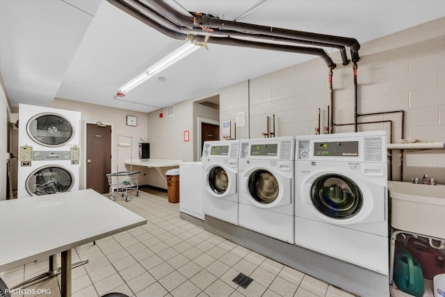 4838 Howard St Unit 301, Skokie, IL 60077 - communal laundry room with washer and dryer, stacked washer / drying machine, and concrete block wall