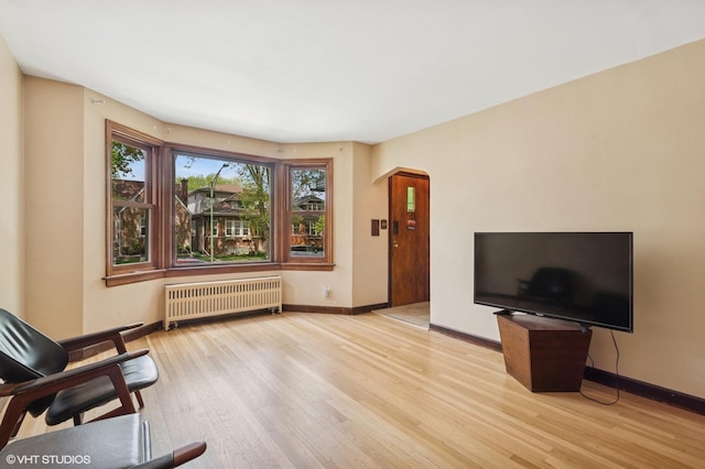 6321 N Merrimac Ave, Chicago, IL 60646 - living area featuring radiator, arched walkways, and wood finished floors