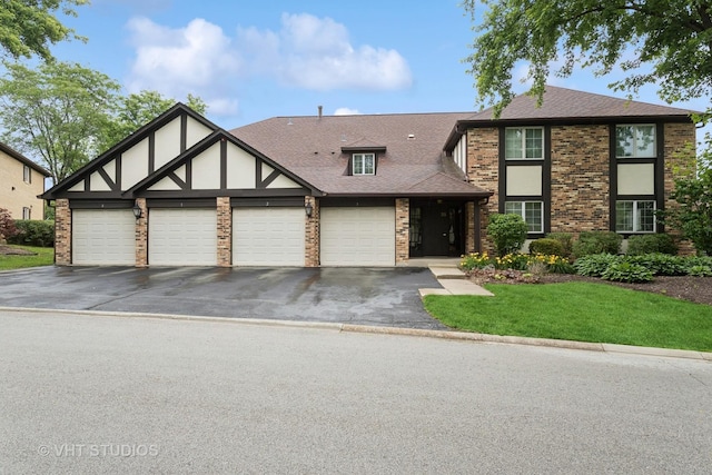 25 Algonquin Trl Unit 1, Indian Head Park, IL 60525 - tudor home with asphalt driveway, an attached garage, a front yard, and roof with shingles