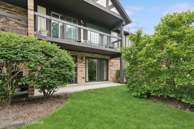 25 Algonquin Trl Unit 1, Indian Head Park, IL 60525 - back of house featuring a balcony, brick siding, and a lawn
