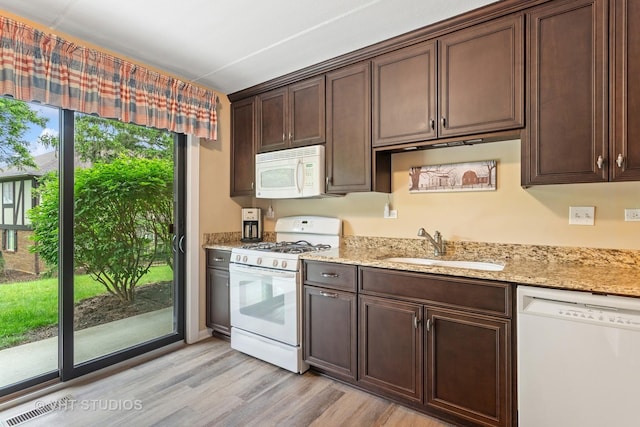25 Algonquin Trl Unit 1, Indian Head Park, IL 60525 - kitchen featuring white appliances, light wood-type flooring, dark brown cabinets, and light stone counters