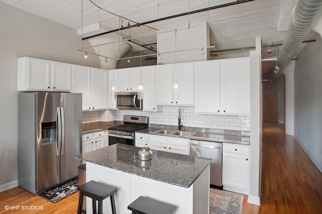 221 E Cullerton St Unit 314, Chicago, IL 60616 - kitchen with appliances with stainless steel finishes, white cabinetry, light wood-style floors, tasteful backsplash, and dark stone countertops